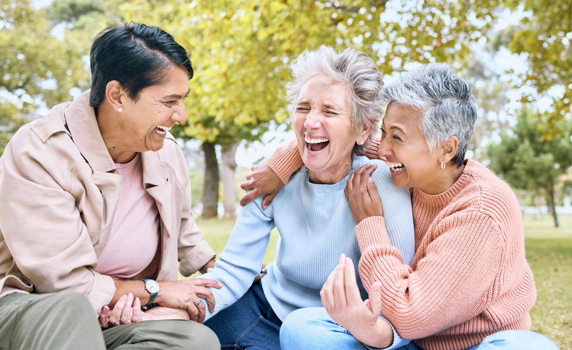 Senior women, laughing and bonding in comic joke, funny meme or silly story in nature park, grass garden or environment. Smile, happy and diversity elderly friends with humour in relax retirement fun